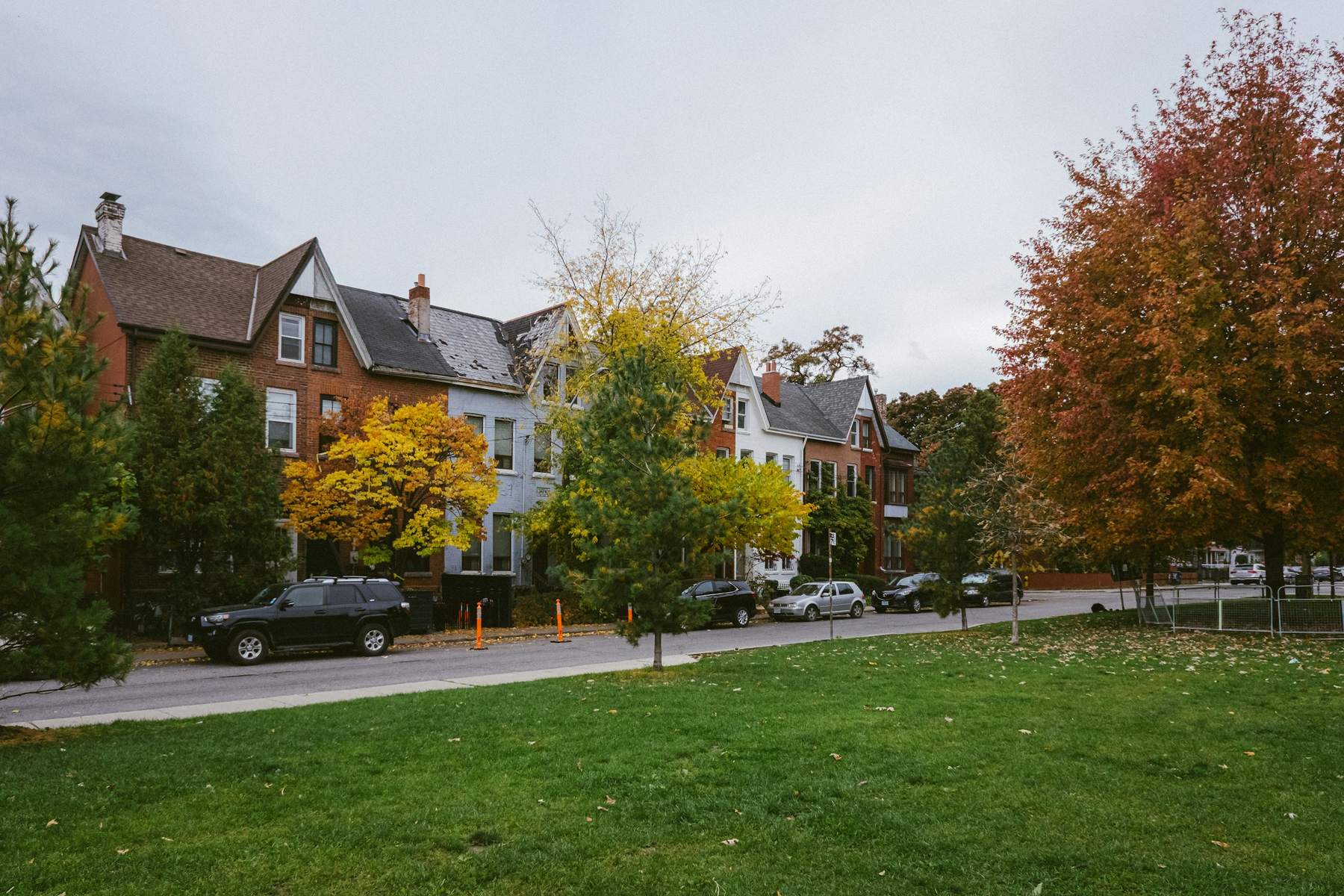 Tree-lined residential street with houses in autumn