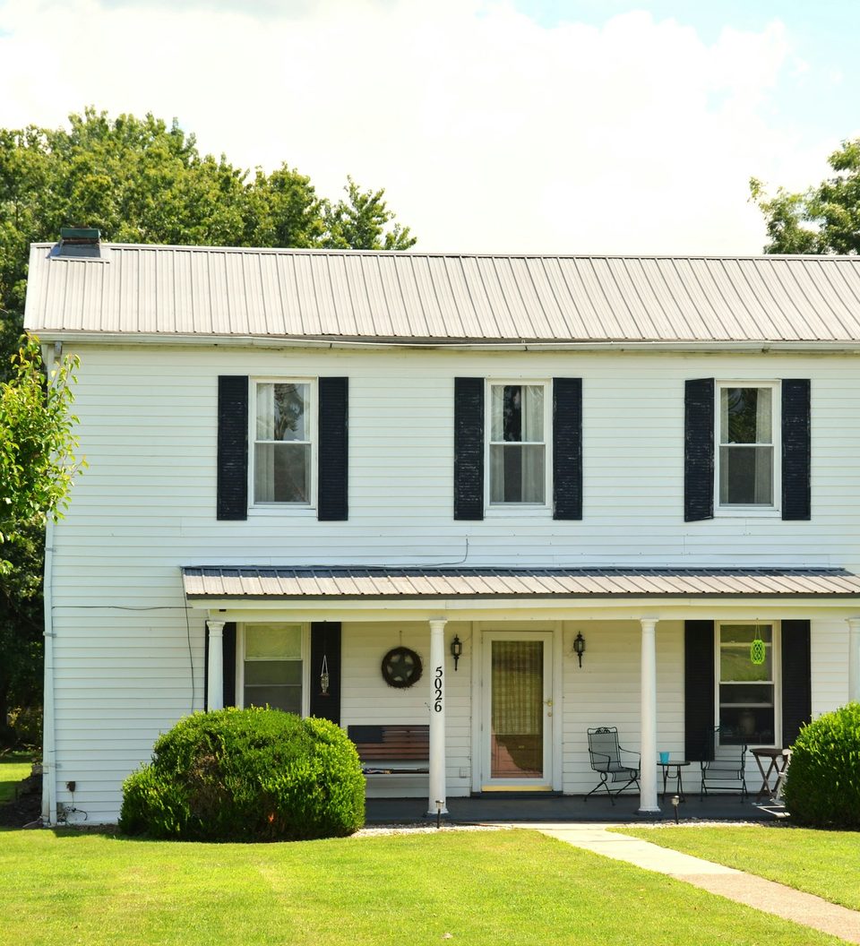 White colonial-style house with a front lawn